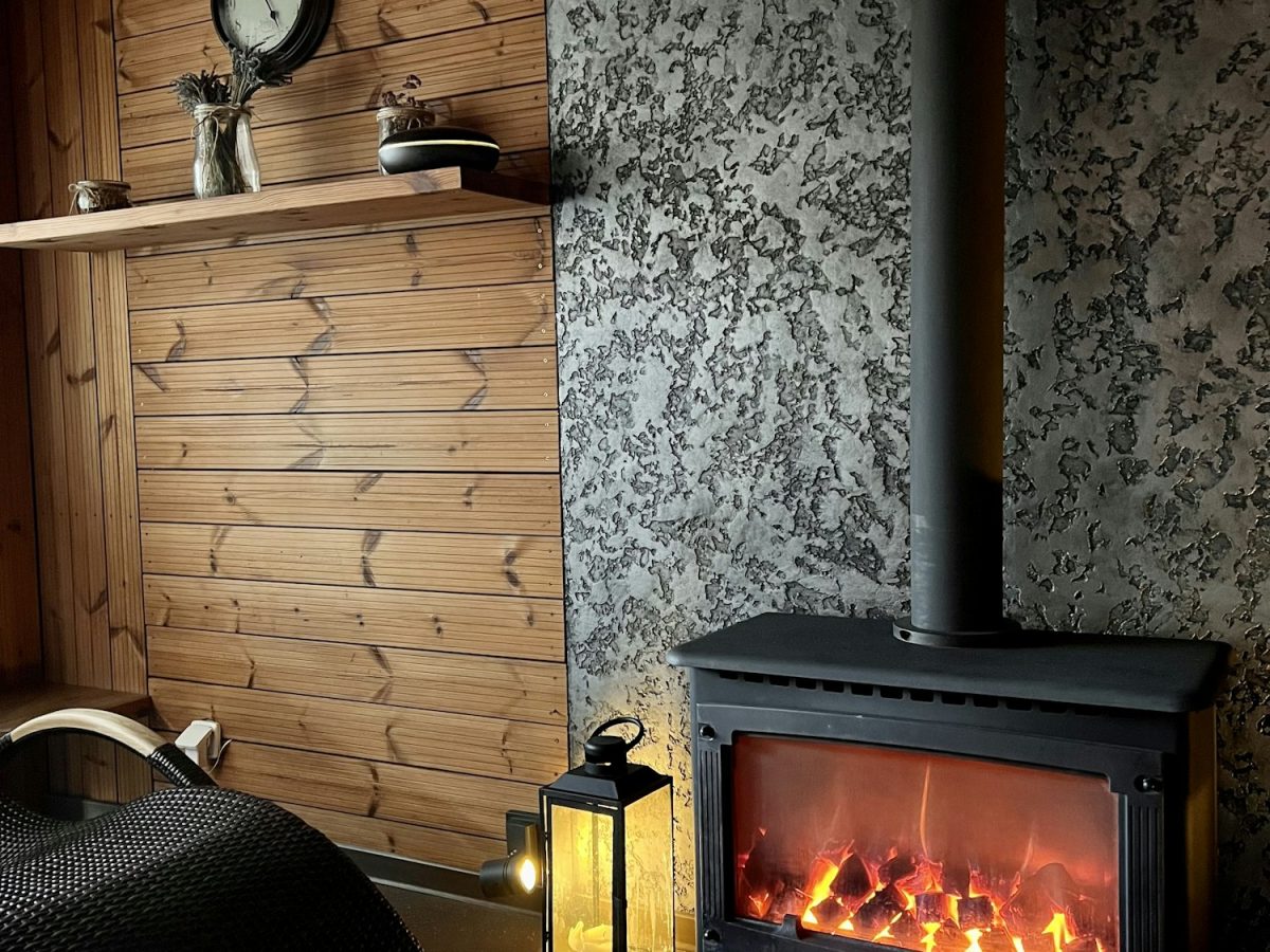 A cozy interior with wood and stone walls and burning fireplace